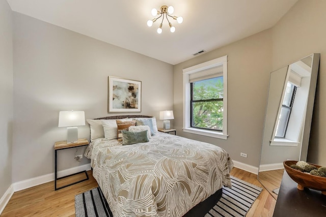 3706 W Wrightwood Ave Unit 3A, Chicago, IL 60647 - bedroom with light wood-style flooring, baseboards, and a chandelier