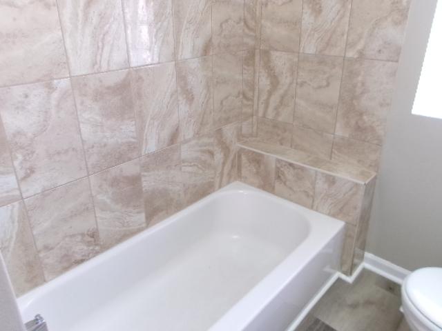 bathroom featuring toilet and a tub