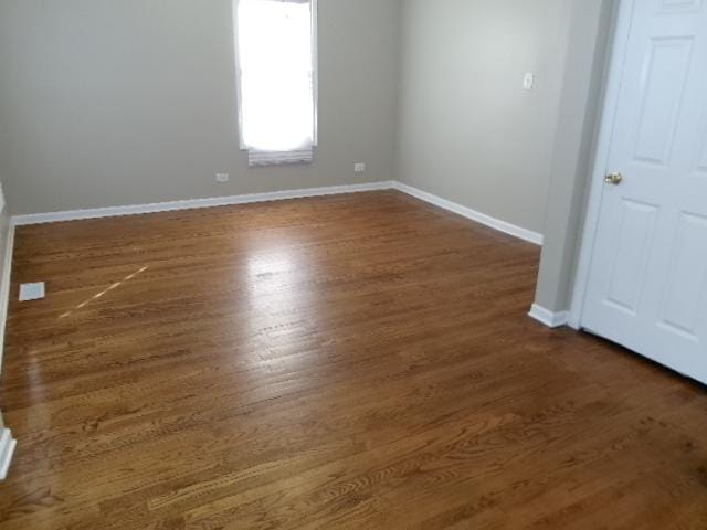 spare room with wood finished floors and baseboards