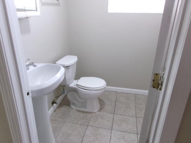 half bath with toilet, tile patterned floors, and baseboards