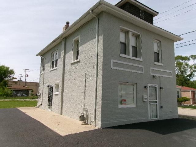 view of side of home with a chimney and a patio area