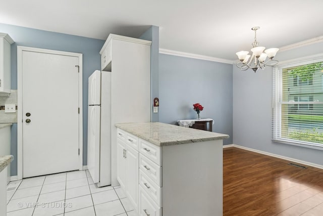 303 College Xing, Rolling Meadows, IL 60008 - kitchen with freestanding refrigerator, a peninsula, a chandelier, white cabinetry, and crown molding