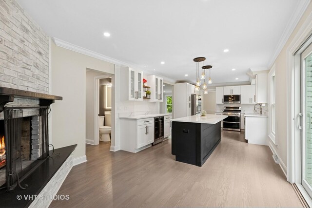 420 N E Gateway Dr, Tower Lakes, IL 60010 - kitchen featuring stainless steel appliances, wine cooler, light countertops, light wood-style flooring, and a center island