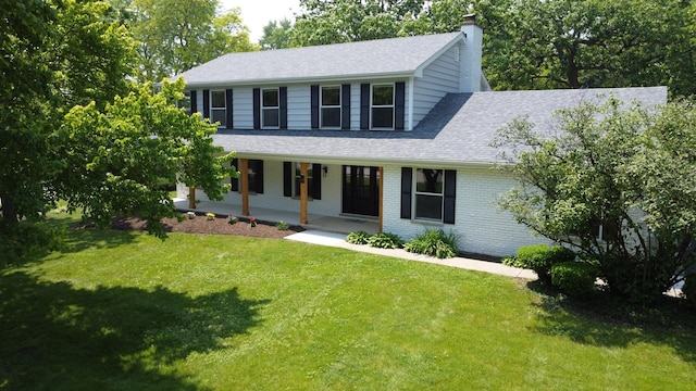 420 N E Gateway Dr, Tower Lakes, IL 60010 - colonial home with covered porch, a shingled roof, a front yard, a chimney, and brick siding