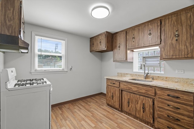 3601 S 57th Ct, Cicero, IL 60804 - kitchen with gas range gas stove, a sink, light wood finished floors, brown cabinets, and baseboards