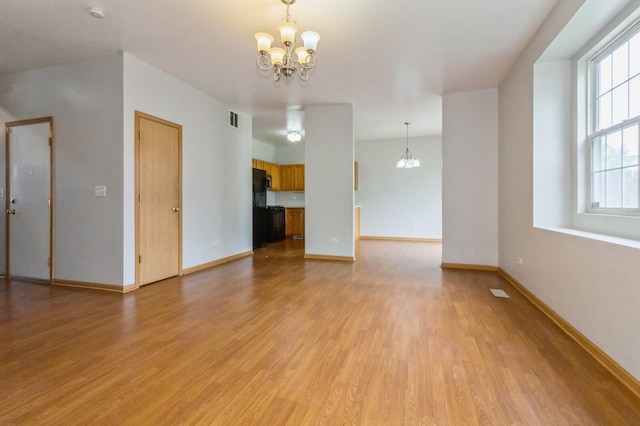 3856 Pathfinder Ln, Joliet, IL 60435 - unfurnished living room with a chandelier, light wood-style floors, and baseboards