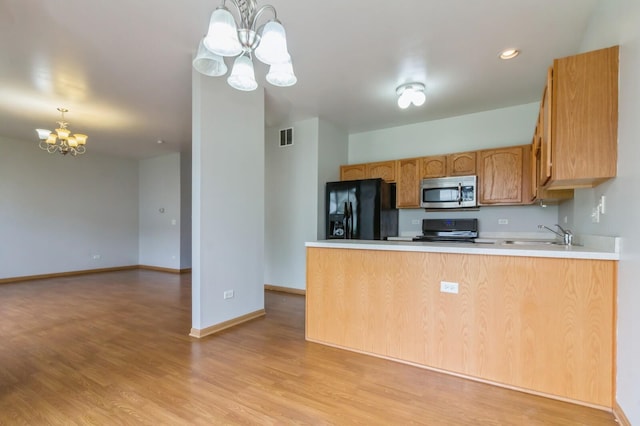 3856 Pathfinder Ln, Joliet, IL 60435 - kitchen featuring appliances with stainless steel finishes, a chandelier, a peninsula, light wood-style flooring, and light countertops