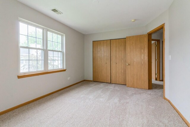 3856 Pathfinder Ln, Joliet, IL 60435 - unfurnished bedroom featuring light carpet, baseboards, and a closet