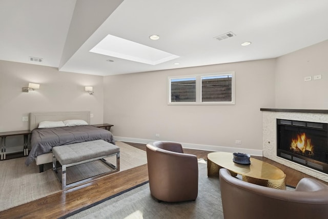 2415 W Washburne Ave, Chicago, IL 60608 - bedroom with a skylight, a lit fireplace, wood finished floors, baseboards, and recessed lighting