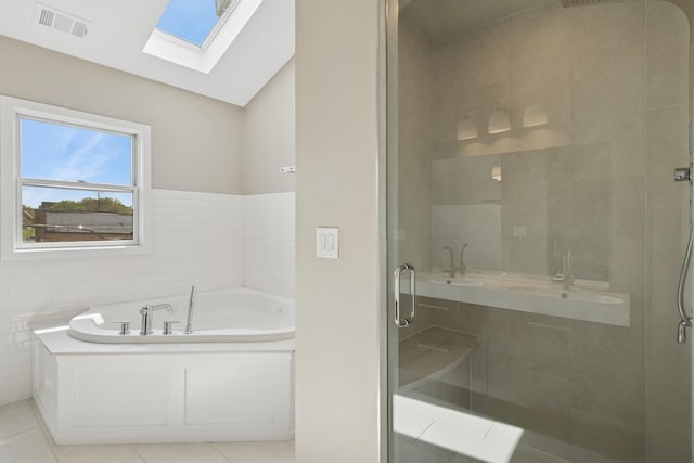 2415 W Washburne Ave, Chicago, IL 60608 - full bathroom featuring a skylight, a shower stall, a bath, a sink, and tile patterned flooring