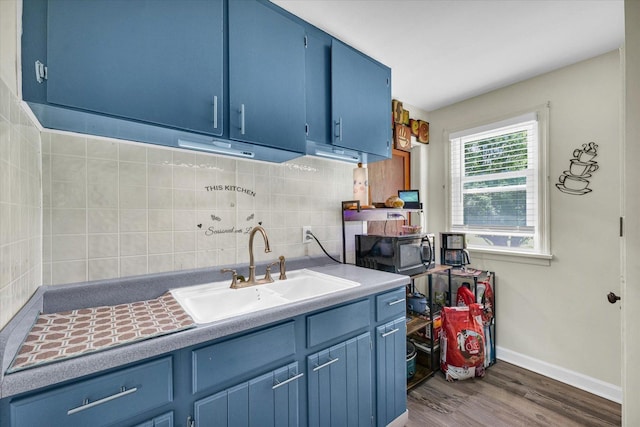 308 W Spruce St, Paxton, IL 60957 - kitchen featuring blue cabinets, a sink, black microwave, and decorative backsplash