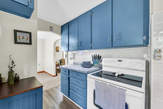 308 W Spruce St, Paxton, IL 60957 - kitchen featuring electric stove, blue cabinetry, arched walkways, wood finished floors, and backsplash