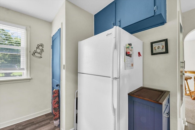 308 W Spruce St, Paxton, IL 60957 - kitchen featuring freestanding refrigerator, blue cabinetry, wood finished floors, and baseboards