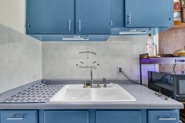 308 W Spruce St, Paxton, IL 60957 - kitchen with blue cabinets, a sink, tasteful backsplash, and black microwave