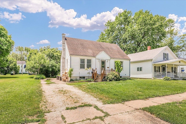 308 W Spruce St, Paxton, IL 60957 - cape cod house with a front lawn, a chimney, covered porch, and driveway