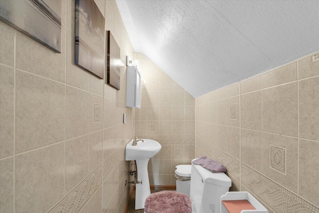 308 W Spruce St, Paxton, IL 60957 - half bathroom featuring toilet, tile walls, a textured ceiling, and vaulted ceiling