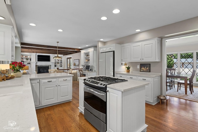 3302 Kingswood Ct, Joliet, IL 60431 - kitchen with stainless steel gas range oven, freestanding refrigerator, a glass covered fireplace, light wood finished floors, and white cabinetry