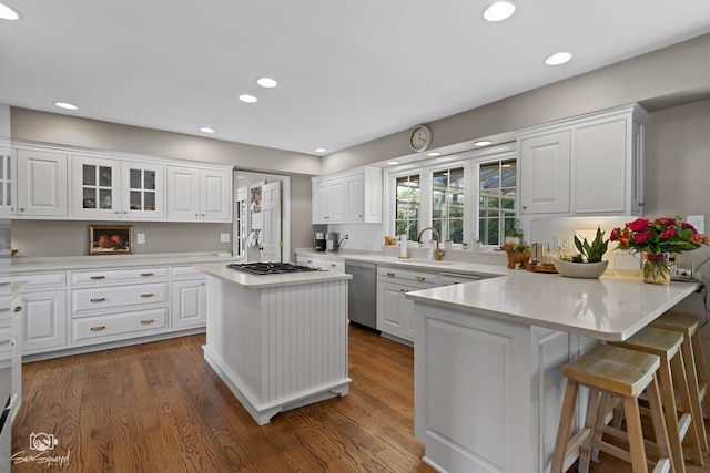 3302 Kingswood Ct, Joliet, IL 60431 - kitchen with stainless steel dishwasher, a peninsula, gas cooktop, a sink, and white cabinetry