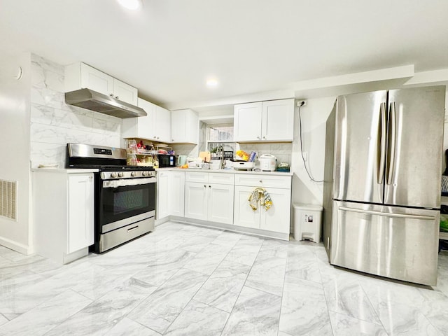 6228 N Artesian Ave, Chicago, IL 60659 - kitchen with stainless steel appliances, under cabinet range hood, white cabinets, light countertops, and decorative backsplash