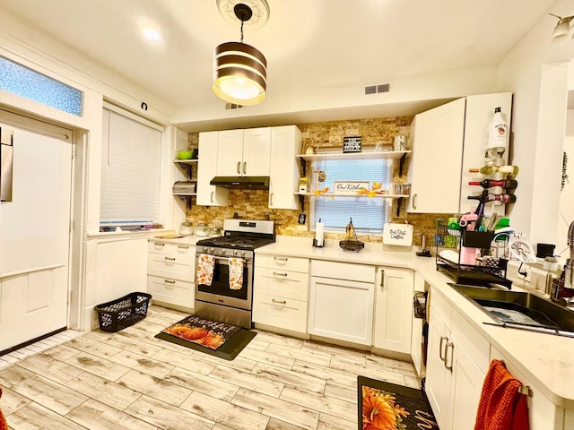 6228 N Artesian Ave, Chicago, IL 60659 - kitchen featuring stainless steel range with gas cooktop, open shelves, decorative backsplash, and white cabinetry