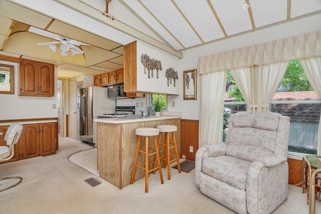 75 Largemouth Ln, Wilmington, IL 60481 - kitchen with freestanding refrigerator, lofted ceiling, light colored carpet, wainscoting, and a breakfast bar