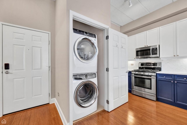 1301 W Washington Blvd Unit 305, Chicago, IL 60607 - laundry area with stacked washer and clothes dryer, light wood-style flooring, and rail lighting