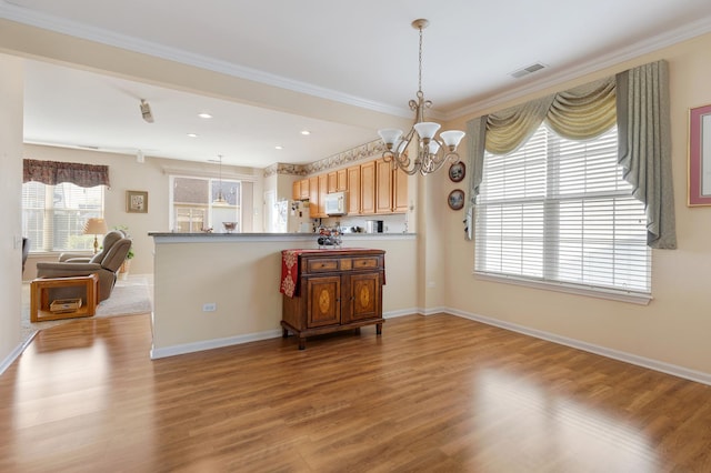 12183 Wildflower Ln, Huntley, IL 60142 - kitchen featuring white appliances, a chandelier, a peninsula, wood finished floors, and baseboards
