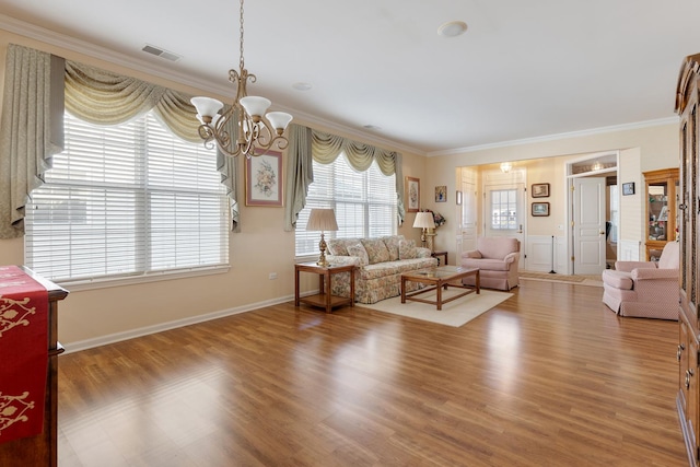12183 Wildflower Ln, Huntley, IL 60142 - living area with ornamental molding, wood finished floors, a chandelier, and wainscoting