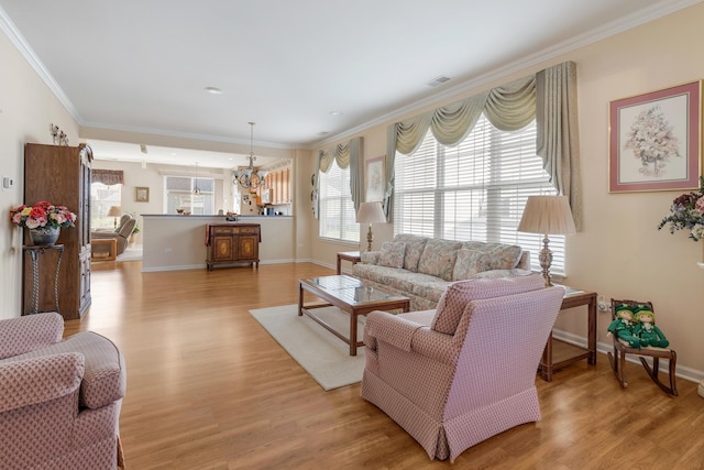12183 Wildflower Ln, Huntley, IL 60142 - living room with crown molding, light wood finished floors, a chandelier, and baseboards