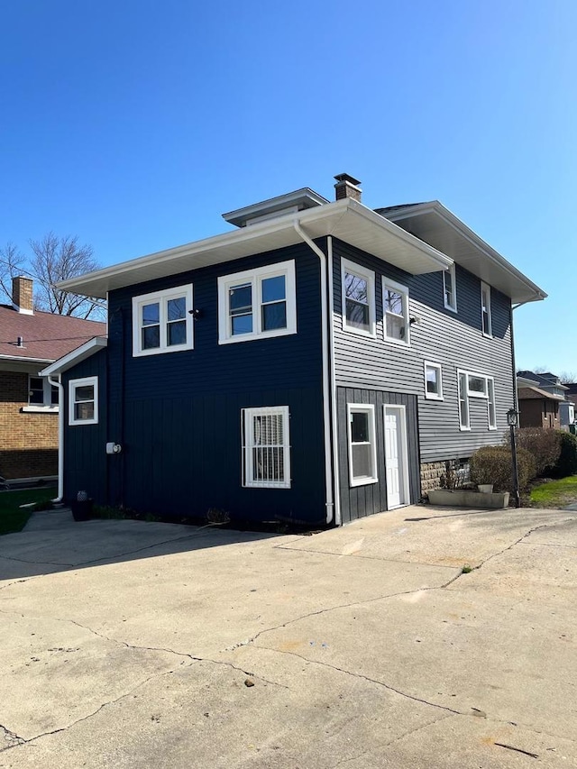 407 N William St, Joliet, IL 60435 - rear view of house with board and batten siding and a chimney