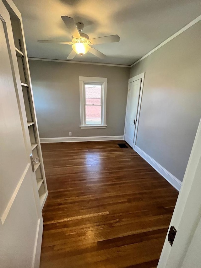 407 N William St, Joliet, IL 60435 - unfurnished room featuring crown molding, baseboards, dark wood finished floors, and ceiling fan