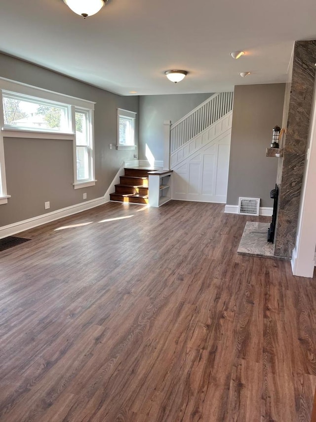 407 N William St, Joliet, IL 60435 - unfurnished living room with stairs, dark wood-style flooring, and baseboards