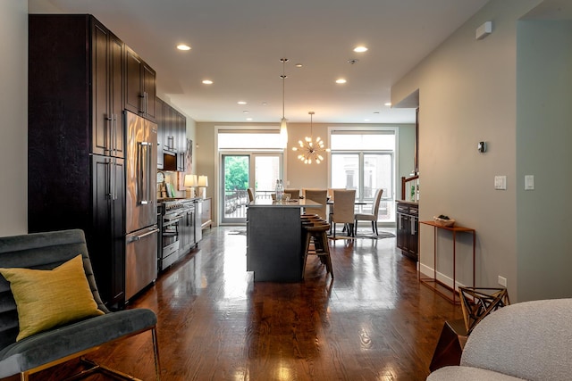 2823 N Oakley Ave Unit K, Chicago, IL 60618 - kitchen featuring high quality appliances, a breakfast bar, dark wood-style flooring, a chandelier, and recessed lighting