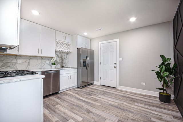 34 W 142nd St, Harvey, IL 60426 - kitchen featuring stainless steel appliances, light countertops, white cabinets, light wood finished floors, and recessed lighting