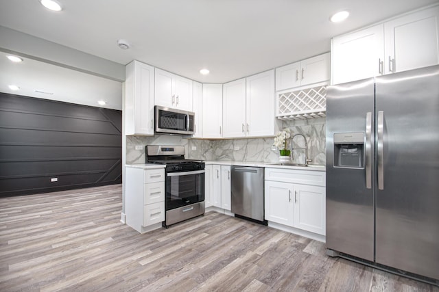 34 W 142nd St, Harvey, IL 60426 - kitchen featuring stainless steel appliances, a sink, light countertops, white cabinetry, and light wood finished floors