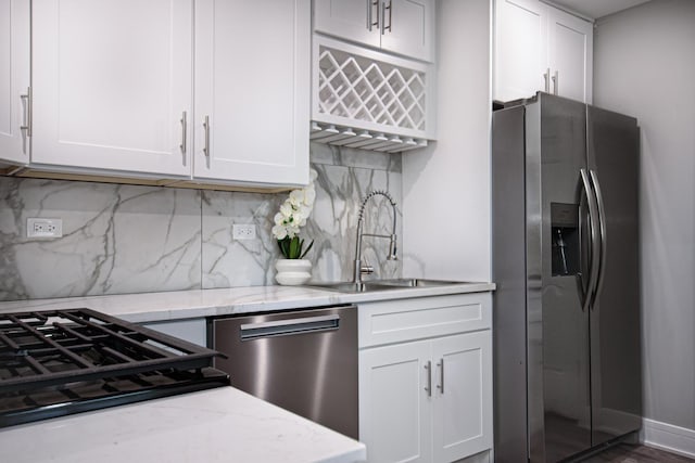 34 W 142nd St, Harvey, IL 60426 - kitchen featuring stainless steel appliances, a sink, white cabinetry, tasteful backsplash, and light stone countertops