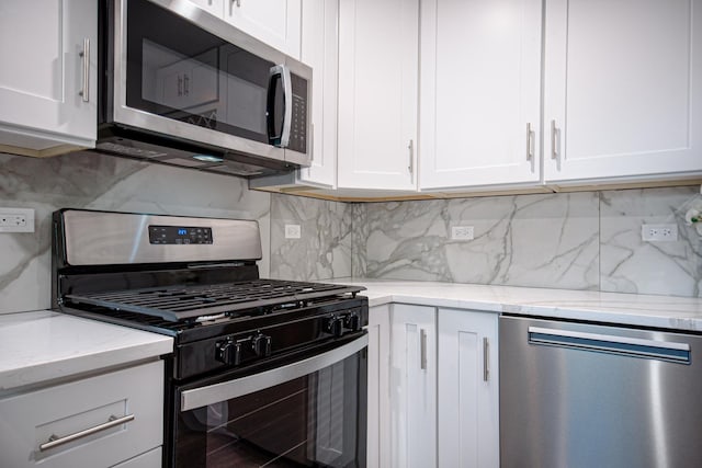 34 W 142nd St, Harvey, IL 60426 - kitchen with appliances with stainless steel finishes, white cabinetry, and backsplash