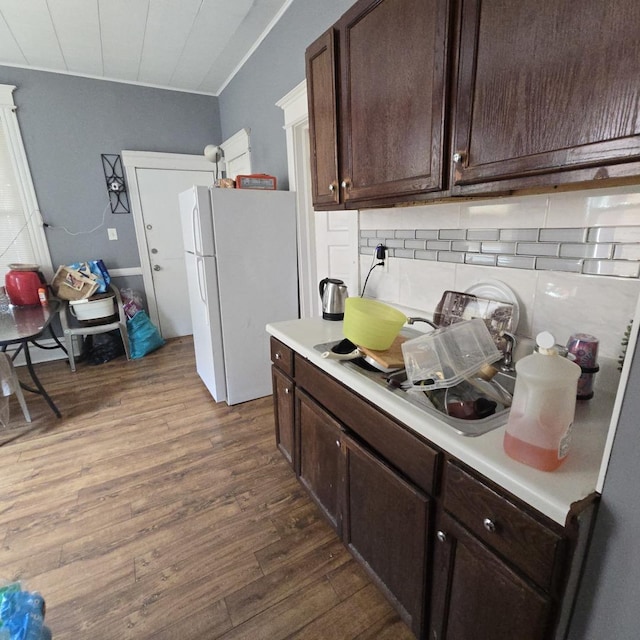 2322 S Trumbull Ave, Chicago, IL 60623 - kitchen featuring freestanding refrigerator, dark wood-style floors, dark brown cabinetry, decorative backsplash, and light countertops