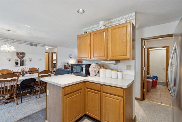5057 Kasch Rd, Pecatonica, IL 61063 - kitchen featuring black microwave, light tile patterned floors, light countertops, and pendant lighting