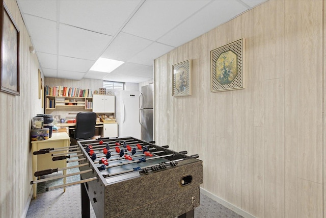 5057 Kasch Rd, Pecatonica, IL 61063 - game room featuring light colored carpet, wooden walls, baseboards, a desk, and a drop ceiling