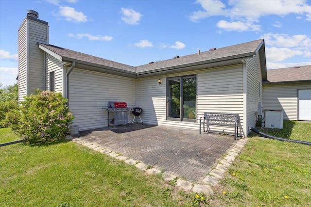 5057 Kasch Rd, Pecatonica, IL 61063 - rear view of house with a patio, a yard, a chimney, and a shingled roof