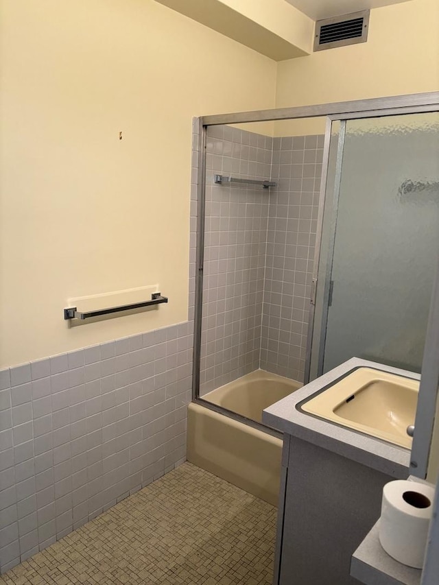 900 N Lake Shore Dr Unit 708, Chicago, IL 60611 - full bath featuring vanity, enclosed tub / shower combo, tile walls, and a wainscoted wall