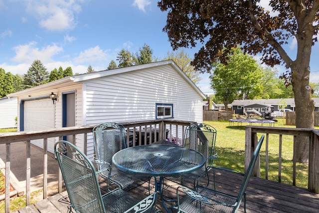 2383 Prairie Ave, Beloit, WI 53511 - wooden deck featuring a trampoline, outdoor dining area, and a detached garage