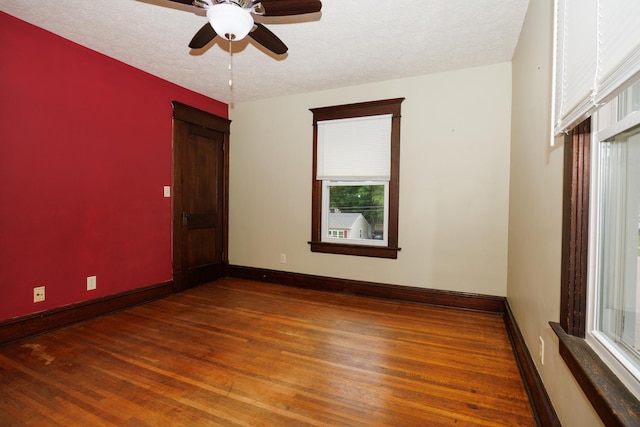 1313 S Madison St, Bloomington, IL 61701 - empty room featuring wood finished floors, ceiling fan, baseboards, and a textured ceiling