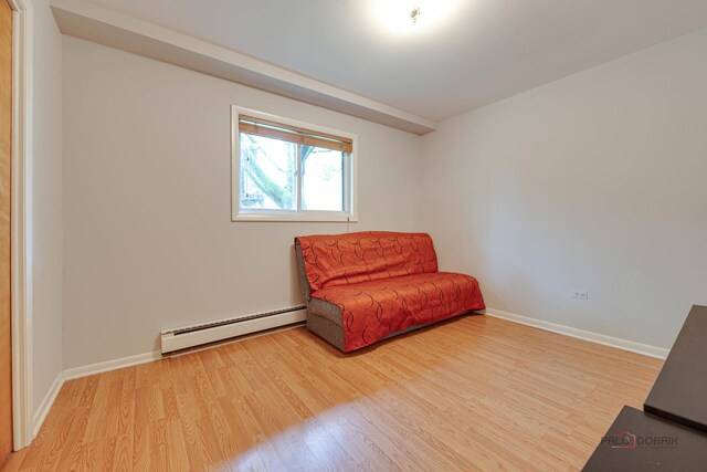 391 Park Ave Unit 102, Highland Park, IL 60035 - living area featuring a baseboard heating unit, wood finished floors, and baseboards
