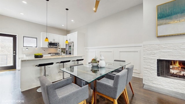 2330 W Armitage Ave Unit B, Chicago, IL 60647 - dining space featuring dark wood-type flooring, a wainscoted wall, a stone fireplace, a decorative wall, and recessed lighting