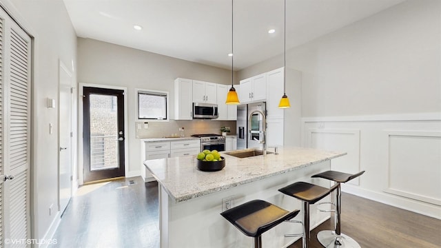 2330 W Armitage Ave Unit B, Chicago, IL 60647 - kitchen with appliances with stainless steel finishes, a sink, dark wood-type flooring, white cabinetry, and light stone countertops