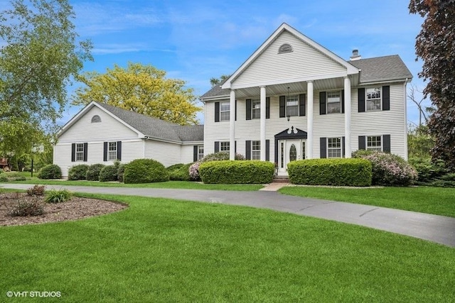 1302 Moraine Dr, Woodstock, IL 60098 - neoclassical home featuring a front yard and a chimney