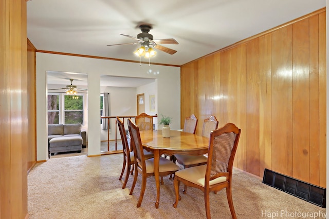 24991 W Forest Dr, Lake Villa, IL 60046 - carpeted dining space with ceiling fan, ornamental molding, wooden walls, and baseboards