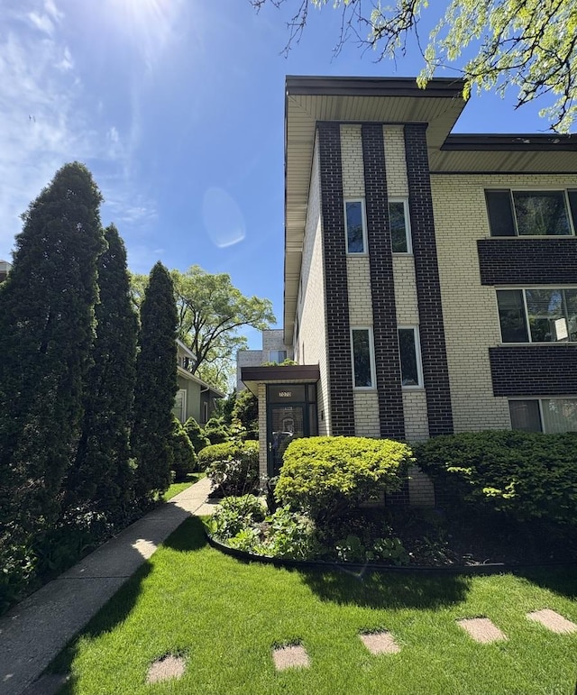 7070 N Ridge Blvd Unit 1B, Chicago, IL 60645 - view of side of property with brick siding and a yard
